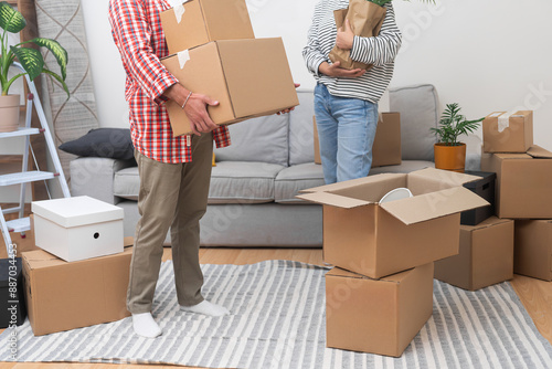Foto New apartment owners carry packed boxes with items for unpacking in living room