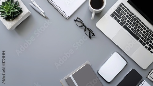 Top view of office essentials including a notepad laptop coffee cup mouse pad and mobile phone with a blank screen Copy space available on the desk workspace photo