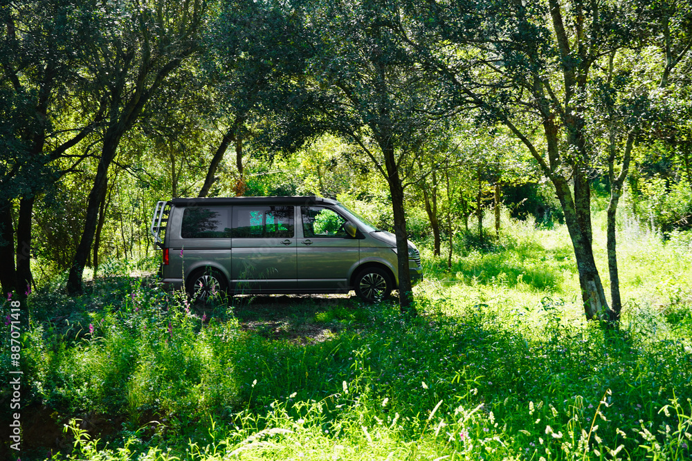 Camper van parked in the middle of the green leafy forest. Camper van parked in the middle of the green leafy forest.