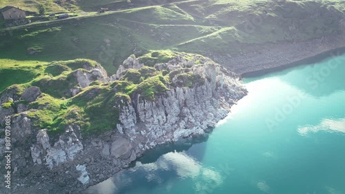 On the shores of Lake Mont Cenis between France and Italy, 4K drone video during a sunrise, green valley with a mystical effect.