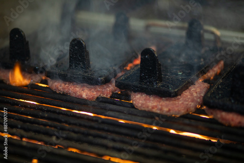 Juicy beef-Hamburger, die über heiße Flammen auf dem Grill schwitzen photo