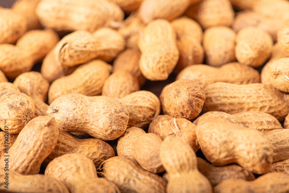 Peanuts, portion of peanuts in shell on a green and white checkered tablecloth. Selective focus. Peanuts, portion of peanuts in shell on a green and white checkered tablecloth. Selective focus.