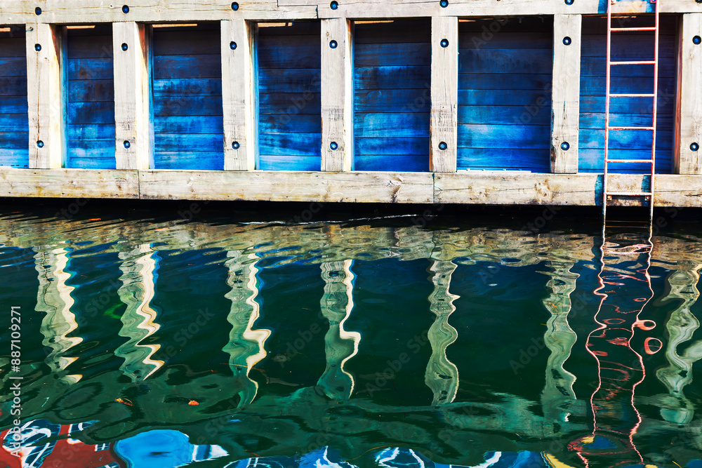 Wooden pier reflection in water canal in Copenhagen Denmark