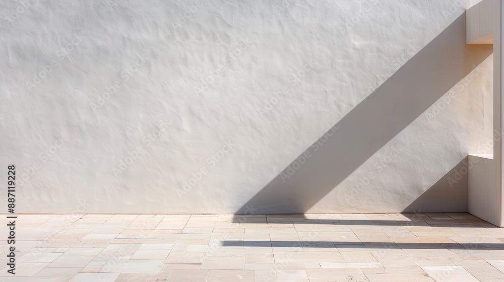 A minimalist architectural scene featuring a white wall with a long diagonal shadow and a simple stone-tiled floor. Sunlight casts dramatic shadows on the surface. A minimalist architectural scene featuring a white wall with a long diagonal shadow and a simple stone-tiled floor. Sunlight casts dramatic shadows on the surface.