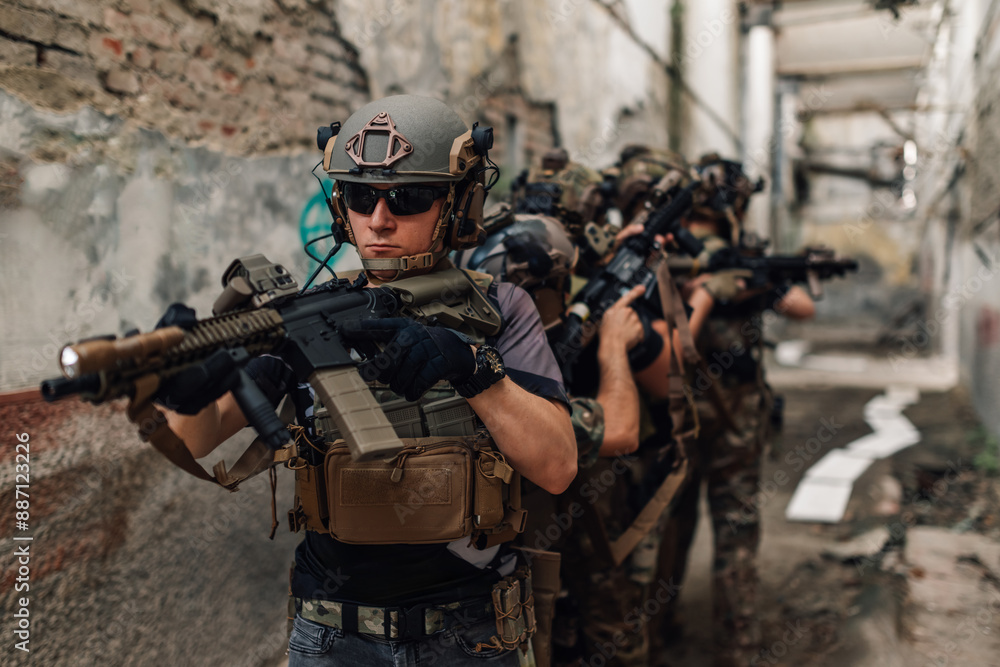 Fototapeta premium Group of armed troops in camouflage uniforms having action at warzone.