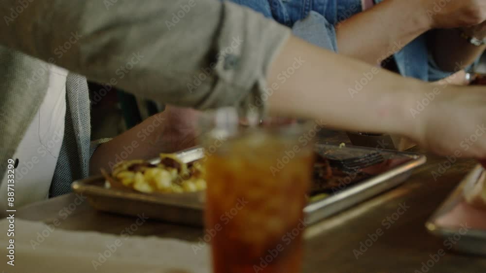 Two people eat barbecue food with a side of macaroni and cheese at a rustic restaurant.� Two people eat barbecue food with a side of macaroni and cheese at a rustic restaurant.�