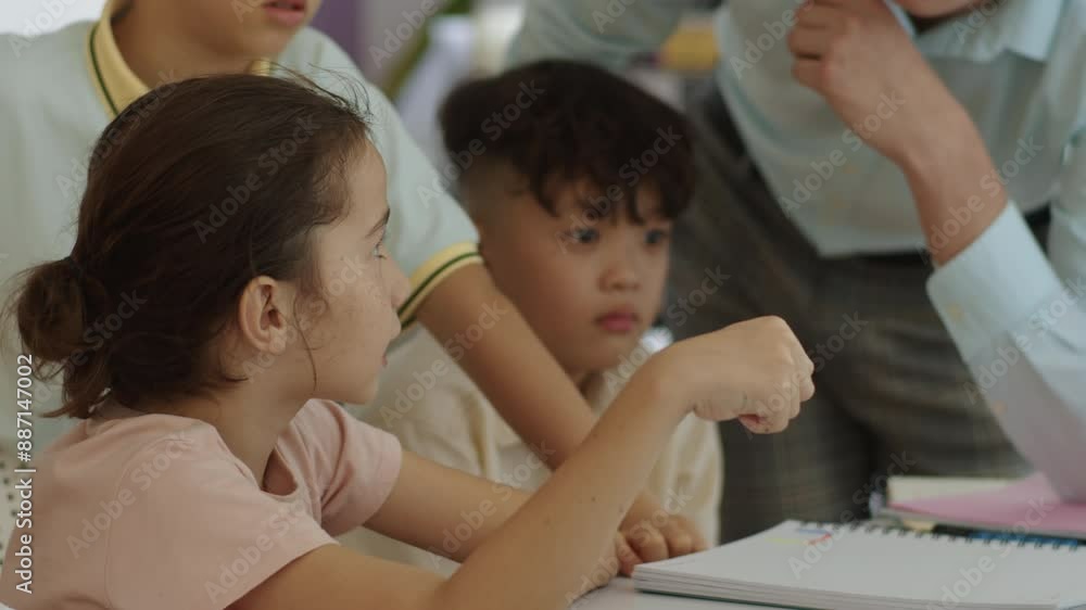 Handheld shot of Caucasian tutor teaching elementary pupils at group class at school Handheld shot of Caucasian tutor teaching elementary pupils at group class at school