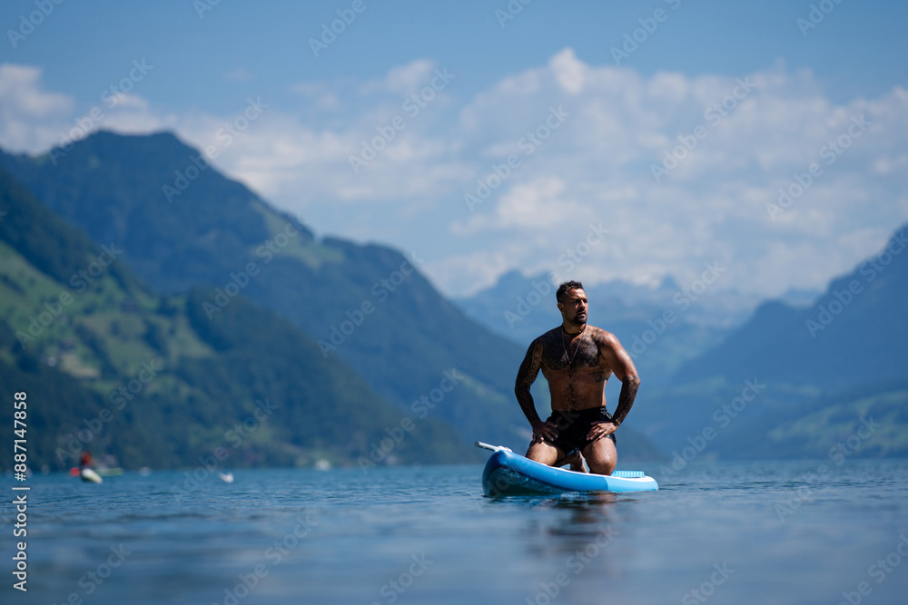 Sexy man with paddle board. Man paddling on paddleboard. Muscular strong Hispanic man on sup board paddle surfing. SUP surfing in summer vacation in Alps lake in Swiss. Strong muscular wet body. Sexy man with paddle board. Man paddling on paddleboard. Muscular strong Hispanic man on sup board paddle surfing. SUP surfing in summer vacation in Alps lake in Swiss. Strong muscular wet body.