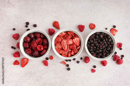 Composition with bowls of tasty freeze-dried berries on light background