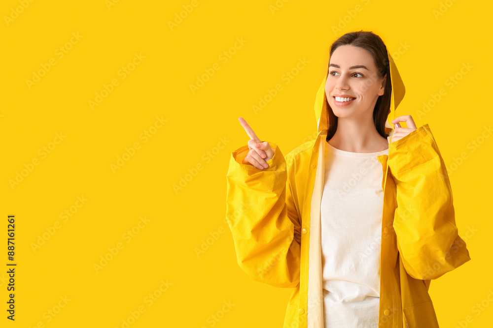 Young happy woman in raincoat on yellow background Young happy woman in raincoat on yellow background