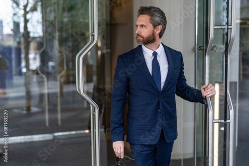 Φωτογραφία Successful banker businessman man in suit entering modern business office buildi