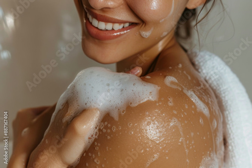 Close up of a woman's hand washing her shoulder with soap