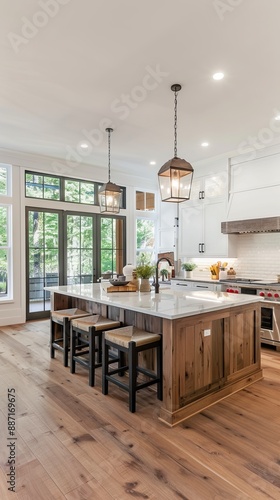 Beautiful living room and kitchen in new luxury home with white cabinets, wood beams, pendant lights and hardwood floors
