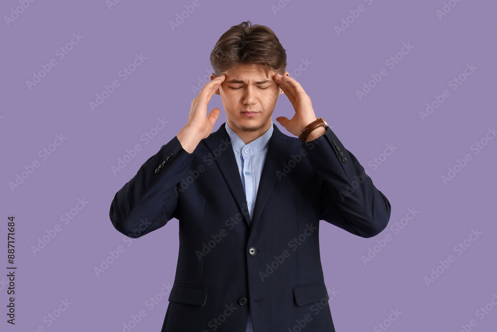 Young businessman suffering from headache on lilac background Young businessman suffering from headache on lilac background