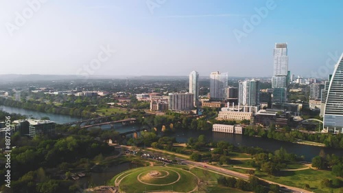 Stunning panoramic 360 pan shot 4K aerial view of downtown Austin, TX, featuring skyscrapers, Lady Bird Lake, Congress Bridge, and Zilker Park on a sunny day photo