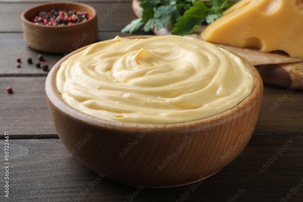Tasty cheese sauce in bowl on wooden table, closeup Tasty cheese sauce in bowl on wooden table, closeup