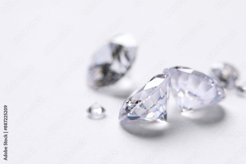 Many beautiful shiny diamonds on white background, closeup Many beautiful shiny diamonds on white background, closeup