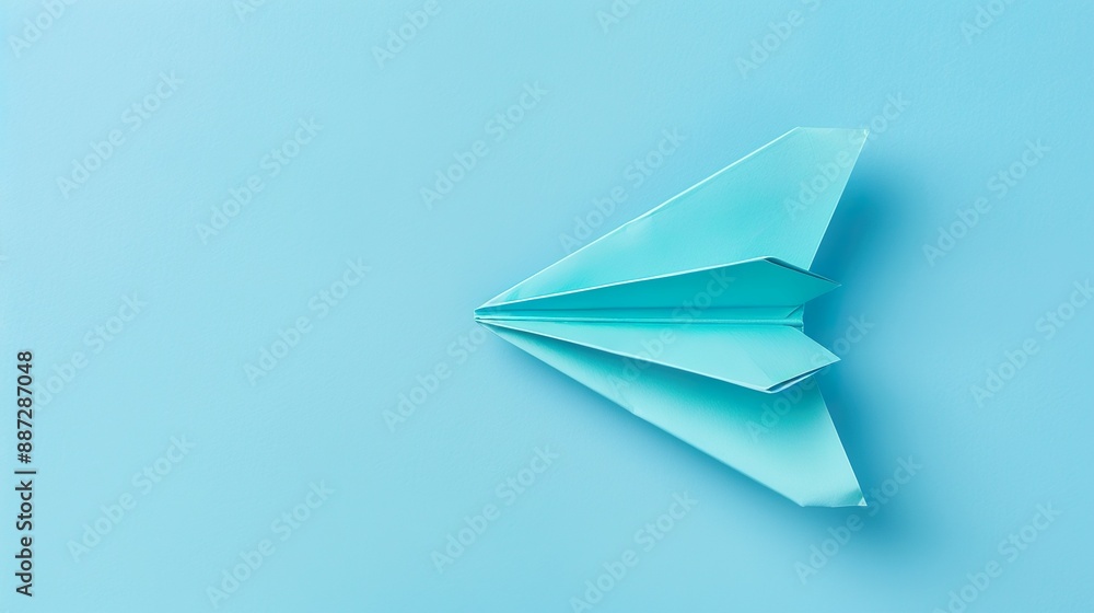 A paper plane with detailed folds and creases, isolated on a pastel blue background. A paper plane with detailed folds and creases, isolated on a pastel blue background.