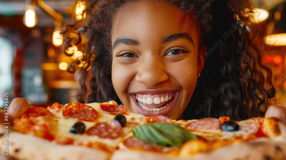 A close-up of a black happy African woman holding a pizza with pepperoni, olives and a basil leaf. Pizza day. Italian cuisine A close-up of a black happy African woman holding a pizza with pepperoni, olives and a basil leaf. Pizza day. Italian cuisine