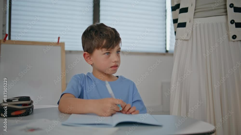 Smart boy writing copybook at lesson closeup. Small schoolboy learning class Smart boy writing copybook at lesson closeup. Small schoolboy learning class