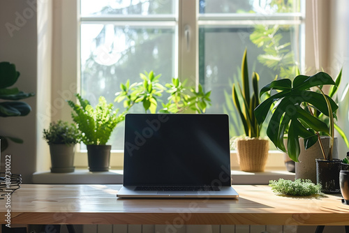 A clean and modern home office setup with a laptop surrounded by vibrant indoor plants on a wooden desk near a sunny window.