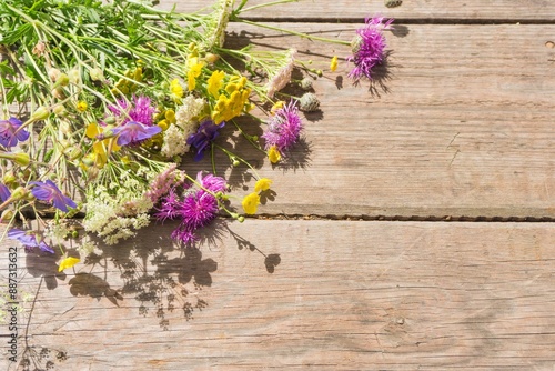 Colorful bouquet of meadow flowers on chalkboard background with empty space. Summer solstice bouquet. Top view, shallow depth of field.