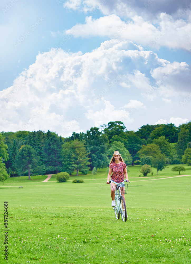 Cycling, woman and happy in countryside for eco friendly or sustainable transportation in park. Blue sky, female person and travel or freedom in nature for journey, adventure and smile for sunshine Cycling, woman and happy in countryside for eco friendly or sustainable transportation in park. Blue sky, female person and travel or freedom in nature for journey, adventure and smile for sunshine