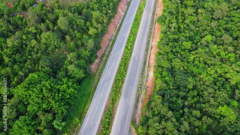Aerial view of countryside asphalt road with car and green forest. Drive on the road between green forests. Aerial view of countryside asphalt road with car and green forest. Drive on the road between green forests.