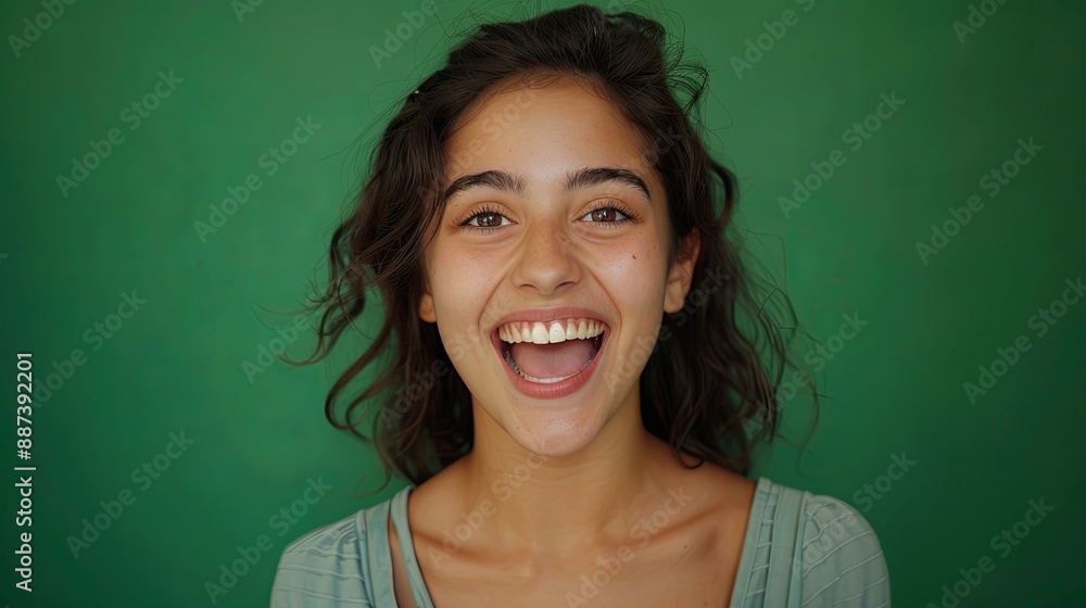 Fototapeta premium Young woman with surprised expression on green background