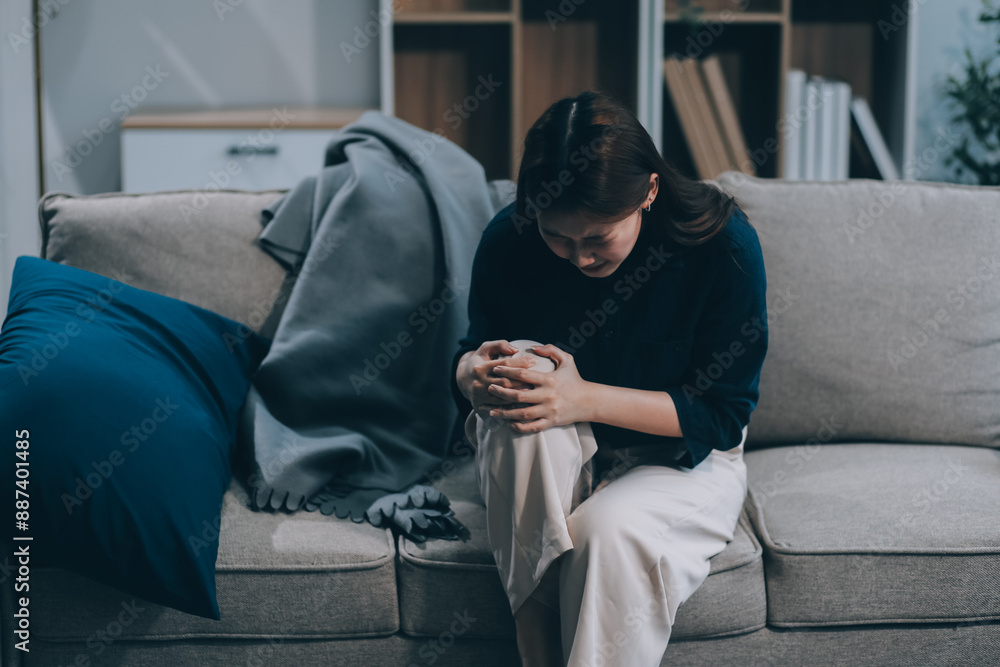 Fototapeta premium A woman with a cold with pills is treated at home chooses which drugs to take and self-medicates, checks the expiration date while sitting on the couch at home