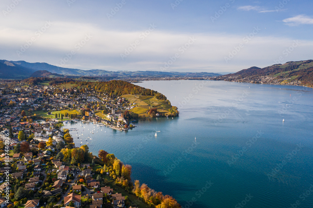 Spiez, Bern: Stunning aerial drone view of lake Thun and the Spiez village with its famous medieval castle and old town in the alps in Canton Bern in Switzerland
