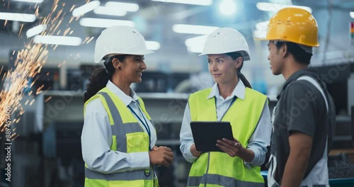 Wallpaper Mural Team of Young Multiethnic Employees Standing in an Industrial Factory Hall. Female Engineer Using a Tablet, Explaining the Scope of Work to Young Technicians. Workers Wearing Hard Hats for Safety Torontodigital.ca