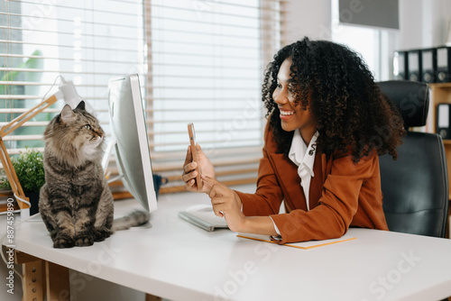 Businesswoman and her office cat, highlighting a relaxed and productive workspace. Perfect for themes of office life, pets photo