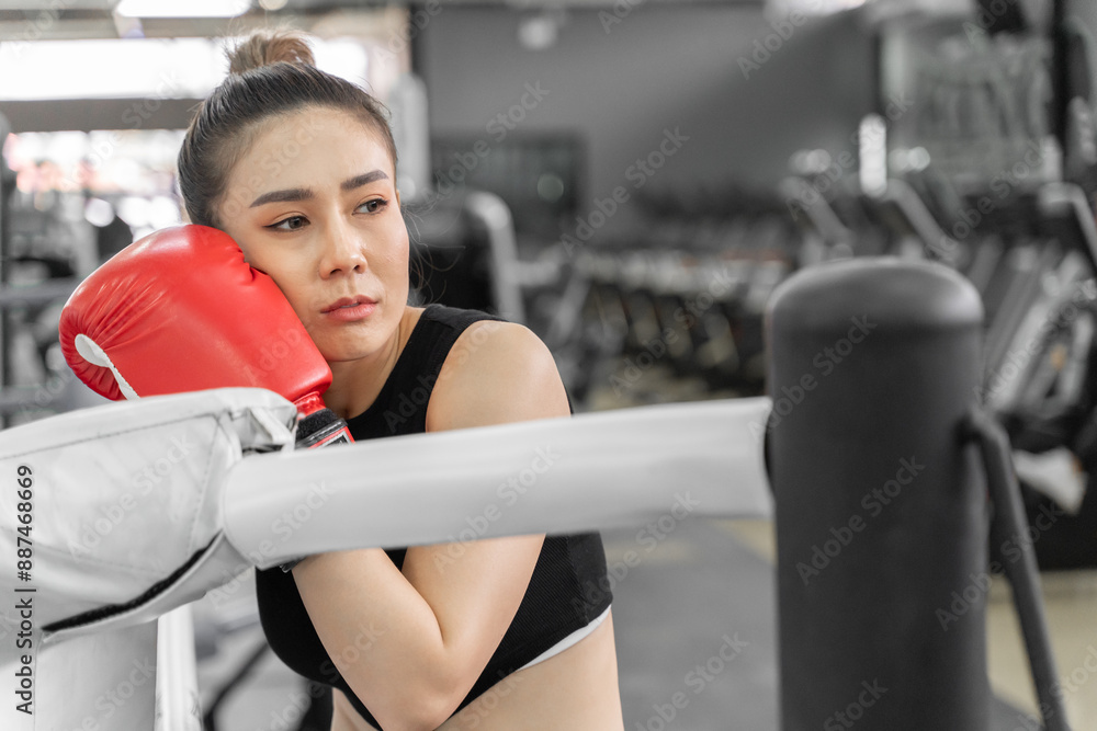 Portrait of a beautiful female boxer resting at the boxing ring in a gym Portrait of a beautiful female boxer resting at the boxing ring in a gym