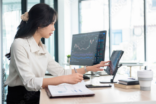 Young woman examines stock graphs at tablet