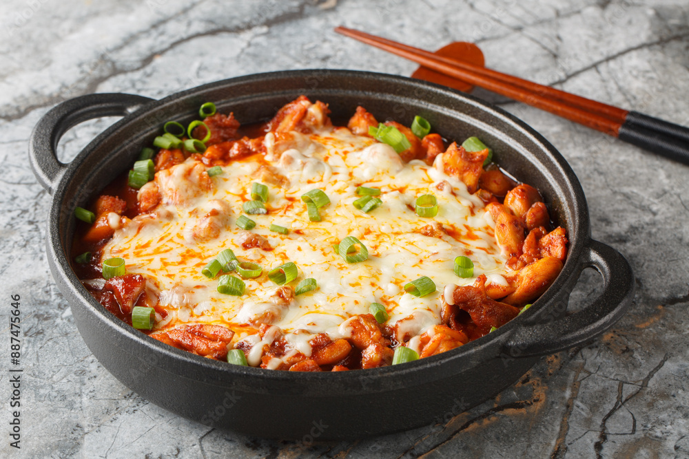 Buldak is a popular Korean spicy chicken dish served as a street food or light meal closeup on the pan on the table. Horizontal
