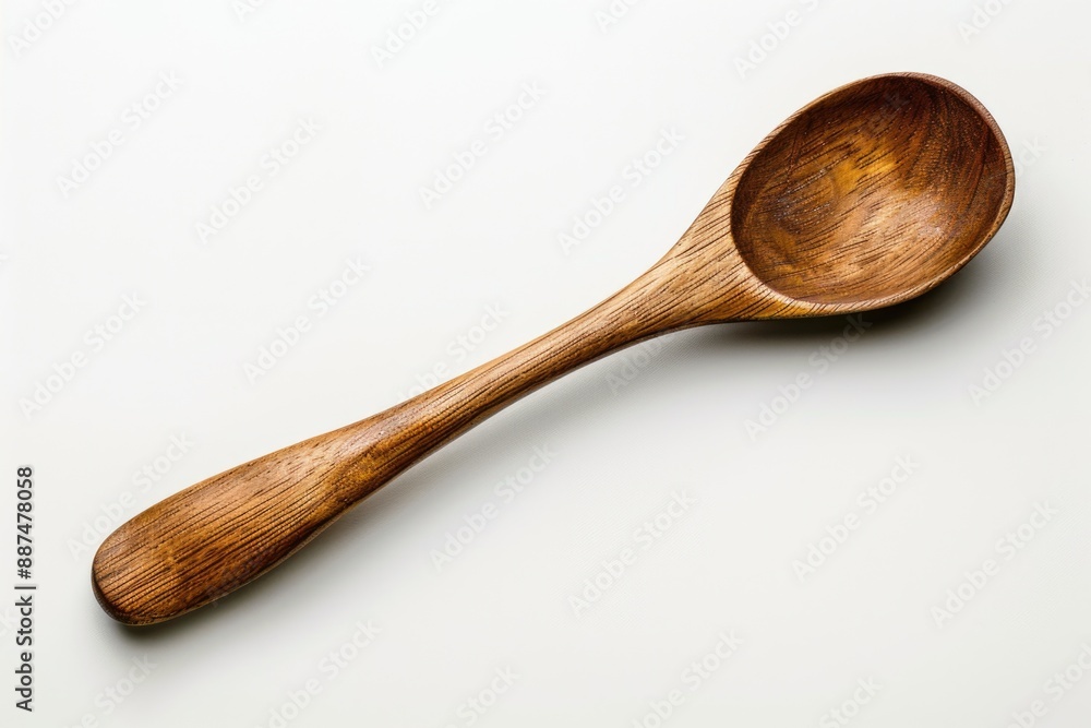 A single wooden spoon lying on a plain white surface A single wooden spoon lying on a plain white surface
