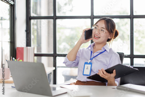 Happy asian business woman call centre representative customer support agent talking to client, smiling asian female working using laptop computer in office.