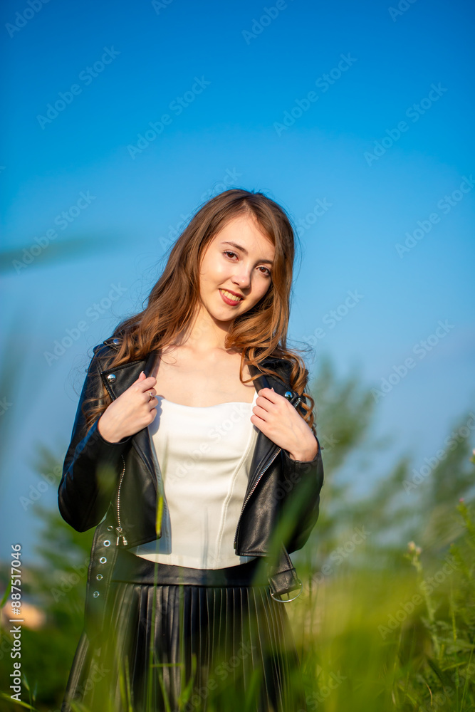 A young smiling girl walks through a spring park in a good mood. Teenage girl, portrait against a background of nature. Fashion style trend. A young smiling girl walks through a spring park in a good mood. Teenage girl, portrait against a background of nature. Fashion style trend.