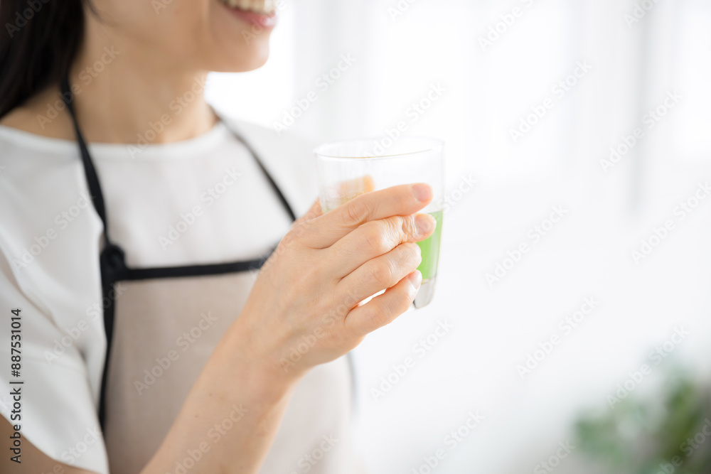 青汁を飲む女性 健康食品などのイメージ 顔無しの手元のクローズアップ 青汁を飲む女性 健康食品などのイメージ 顔無しの手元のクローズアップ