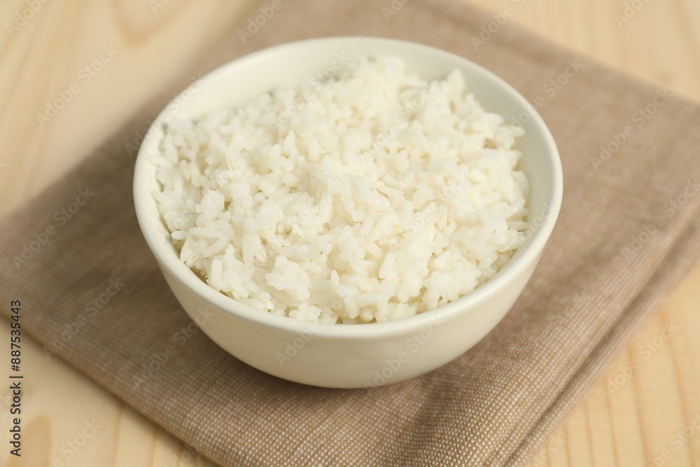 Delicious boiled rice in bowl on wooden table, closeup Delicious boiled rice in bowl on wooden table, closeup