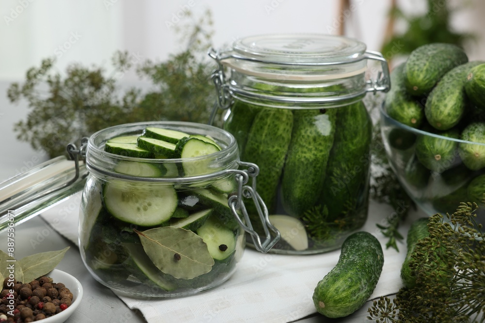 Homemade pickles. Fresh cucumbers in jars and other ingredients on table, closeup Homemade pickles. Fresh cucumbers in jars and other ingredients on table, closeup