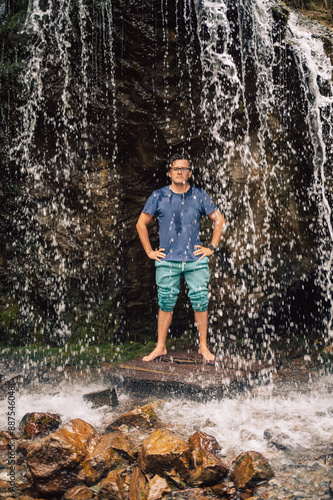 Man at waterfall in summer ...