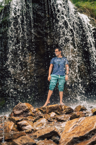 Man at waterfall in summer ...