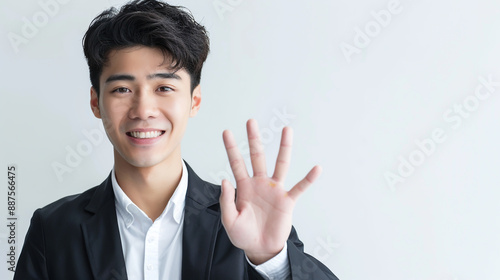 A dapper young entrepreneur displaying five fingers to the camera. photo