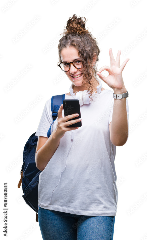 Young brunette student girl wearing backpack, headphones and smartphone over isolated background doing ok sign with fingers, excellent symbol Young brunette student girl wearing backpack, headphones and smartphone over isolated background doing ok sign with fingers, excellent symbol