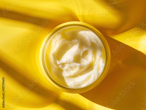 a jar of cream on a yellow surface