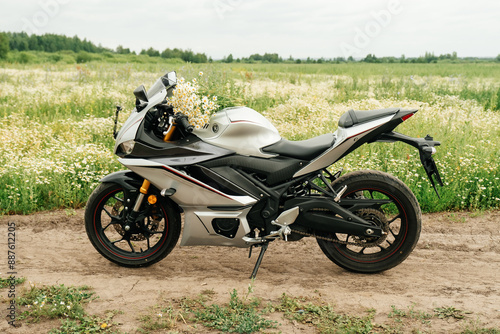 A motorcycle in a field with daisies. Summer, daisies.