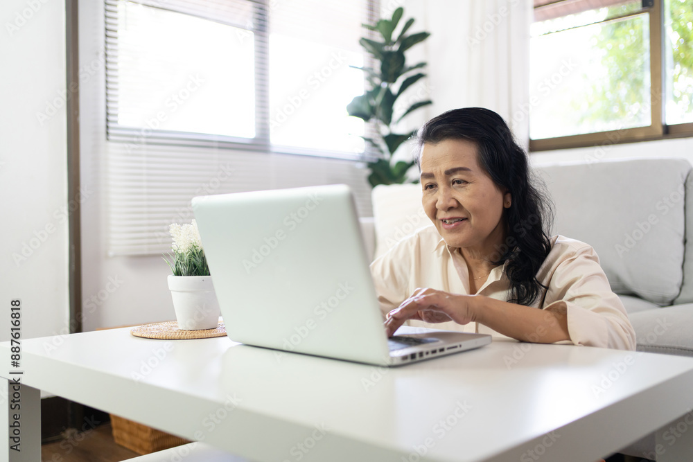 Middle age Asian woman Work from home. senior woman smiling Beautiful mature asian woman on laptop with technology concept Middle age Asian woman Work from home. senior woman smiling Beautiful mature asian woman on laptop with technology concept