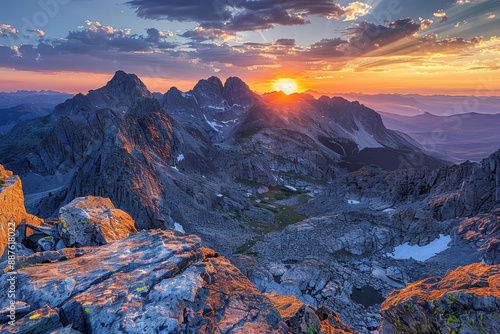 Spectacular mountain sunset with colorful skies over rugged peaks and valleys, showcasing nature's breathtaking beauty and serene landscape.